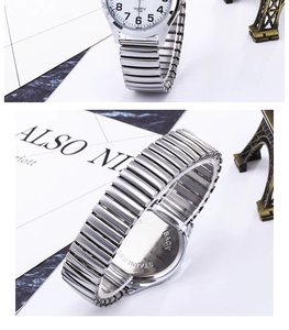 Detail view of quartz watch with stretch band and stainless steel back on marble surface
