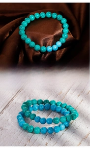Macro detail of turquoise beaded bracelet with black matrix texture on silk and wood