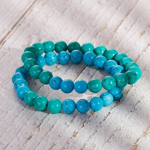Retro turquoise beaded bracelets for men and women on vintage white wood background