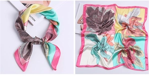 Detail of satin floral scarf showing colorful botanical prints and silky smooth texture