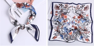 Detail of silk satin square scarf with orange floral prints and navy blue border