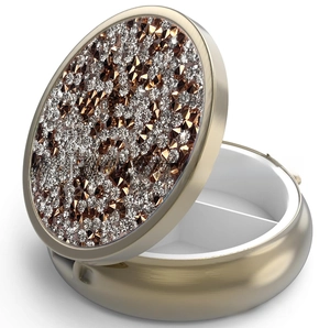 Detail of a round metal pill box featuring sparkling rhinestones and an internal divider