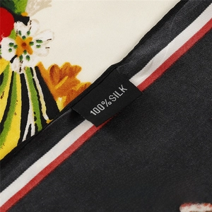 Detailed macro view of 100% silk twill scarf showing high-quality fabric texture and label