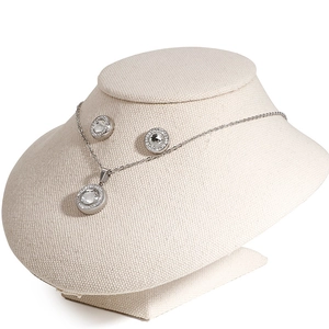 Silver jewelry set with round crystal pendant and stud earrings on a display