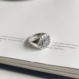 Macro shot of 925 silver vintage eye ring with intricate engraving on a magazine