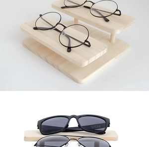 Macro detail of a two-tier solid wood eyewear display stand for sunglasses and frames