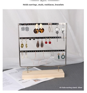 Three-tier silver metal earring display stand with 69 holes and a natural wooden base