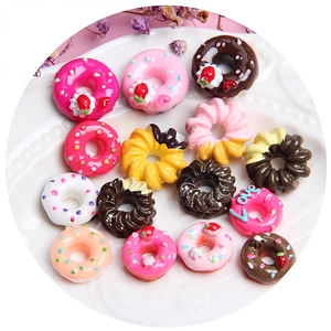 Assorted miniature resin donuts for DIY crafts and phone case decorations on a white plate