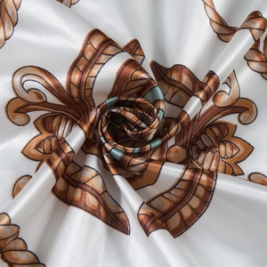 Macro detail of silk-like scarf fabric showing elegant brown and orange baroque patterns