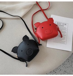 Detail shot of cute cartoon pig-shaped crossbody bags in red and black colors