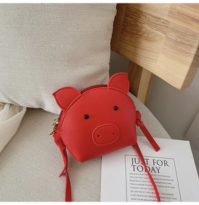 Detail of red cartoon pig shoulder bag for kids made of smooth synthetic PU leather