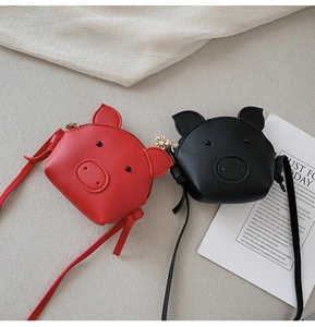 Detail showing two cute pig-shaped PU leather crossbody bags in red and black colors
