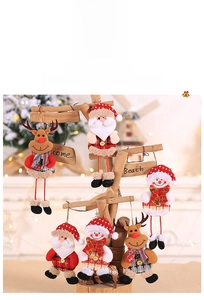 Close-up of plush Santa, snowman, and reindeer ornaments with red plaid fabric detailing
