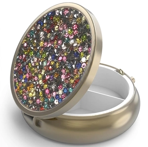 Close-up of portable round metal pill box with colorful rhinestones and two compartments