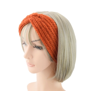 Detail of orange knitted cross knot headband with thick texture on model head