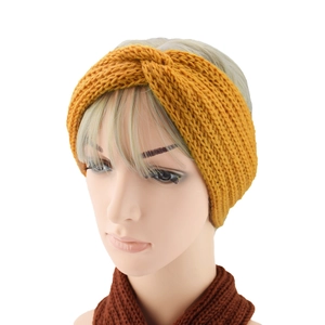 Close-up of ginger yellow knitted headband with cross twist knot on a mannequin head