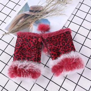 Detail of red leopard print faux fur leg warmers with fluffy trim and decorative pom-poms