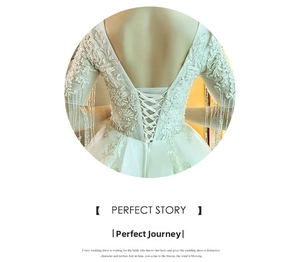 Exquisite back detail of a bridal gown featuring a lace-up corset and beaded fringe sleeves