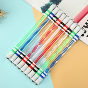 Set of 11 colorful spinning pens with metal weighted ends on a blue and yellow surface