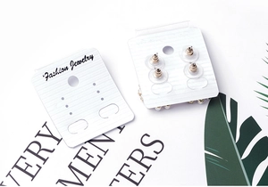 Close-up of white PVC earrings display cards featuring Fashion Jewelry printed text