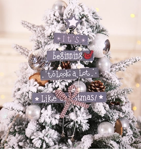 Detail of wooden Christmas tree hanging with pine cones and festive lettering