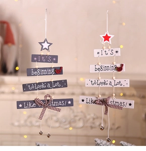 Detail of wooden Christmas tree hanging signs with bells and festive bow decoration