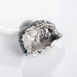 Cartoon hedgehog brooch made of silver alloy with detailed spikes and pink foot accents