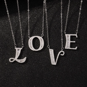 Sterling silver LOVE letter necklaces with square zircon stones on black background