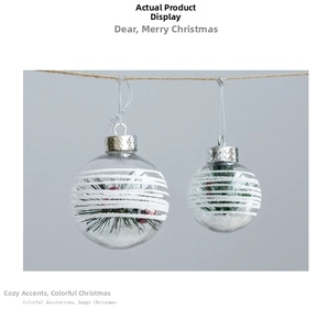 Detail of 6cm clear Christmas ornaments with snow, pine needles, and berries inside