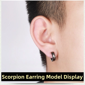 Close-up of black punk clip-on earring featuring a white scorpion pattern on a male ear