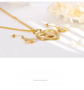 Close-up of gold heart pendant necklace and earrings set on elegant floral background