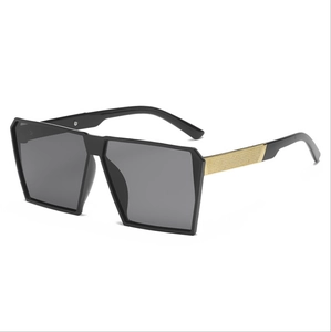 Oversized square sunglasses with black frames and gold-textured metal temples on white background