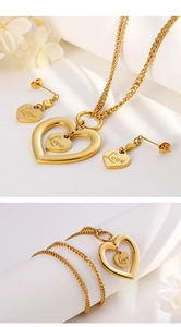 Detail of gold double heart LOVE necklace and earrings set with multilayer chain