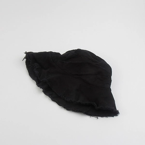 Detailed close-up of the raw fringe edge and cotton texture on the black bucket hat