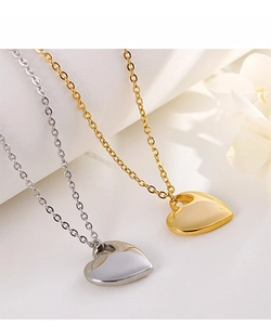 Dettaglio di ciondoli a cuore lucidi in oro e argento su petali di fiori bianchi eleganti