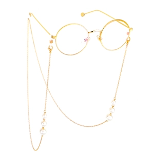 Detailed close-up of golden round metal frame glasses with white pearl eyewear chain
