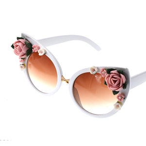 Close-up of cat-eye sunglasses with white frame and 3D resin roses on sides