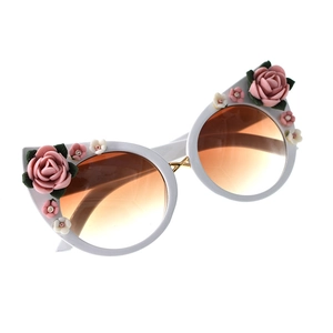 Detail of white cat eye sunglasses with 3D pink rose floral accents and gradient lenses