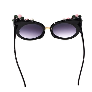 Detailed view of floral cat eye sunglasses with purple gradient lenses and pink rose decor
