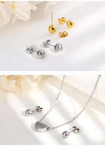 Detailed set of gold and silver ball earrings with a heart pendant necklace on floral background