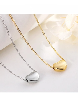 Close-up of polished heart pendant necklaces in gold and silver finish on white background