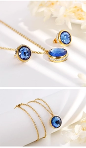 Detail view of golden jewelry set featuring blue round zircon necklace and stud earrings