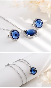 Detail of silver stainless steel necklace and earrings set with blue round crystals