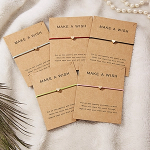 Five-piece heart charm woven bracelets set in multiple colors on a kraft display card