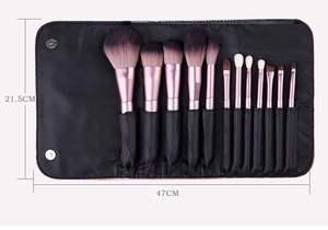 Detailed view of 12-piece makeup brush set with purple bristles in black leather pouch