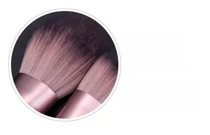 Detail of pink metal ferrule and purple gradient synthetic bristles for makeup brush
