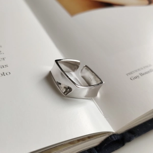 Detailed close-up of S925 sterling silver minimalist geometric ring on a book page