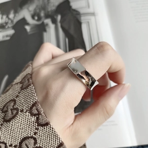 Macro shot of wide irregular geometric sterling silver ring on finger with high polish finish