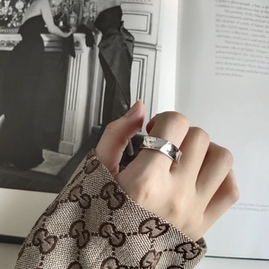 Close-up of a minimalist irregular wide 925 sterling silver ring with a textured finish