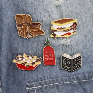 Set of creative enamel pins featuring sofa and food designs on denim fabric